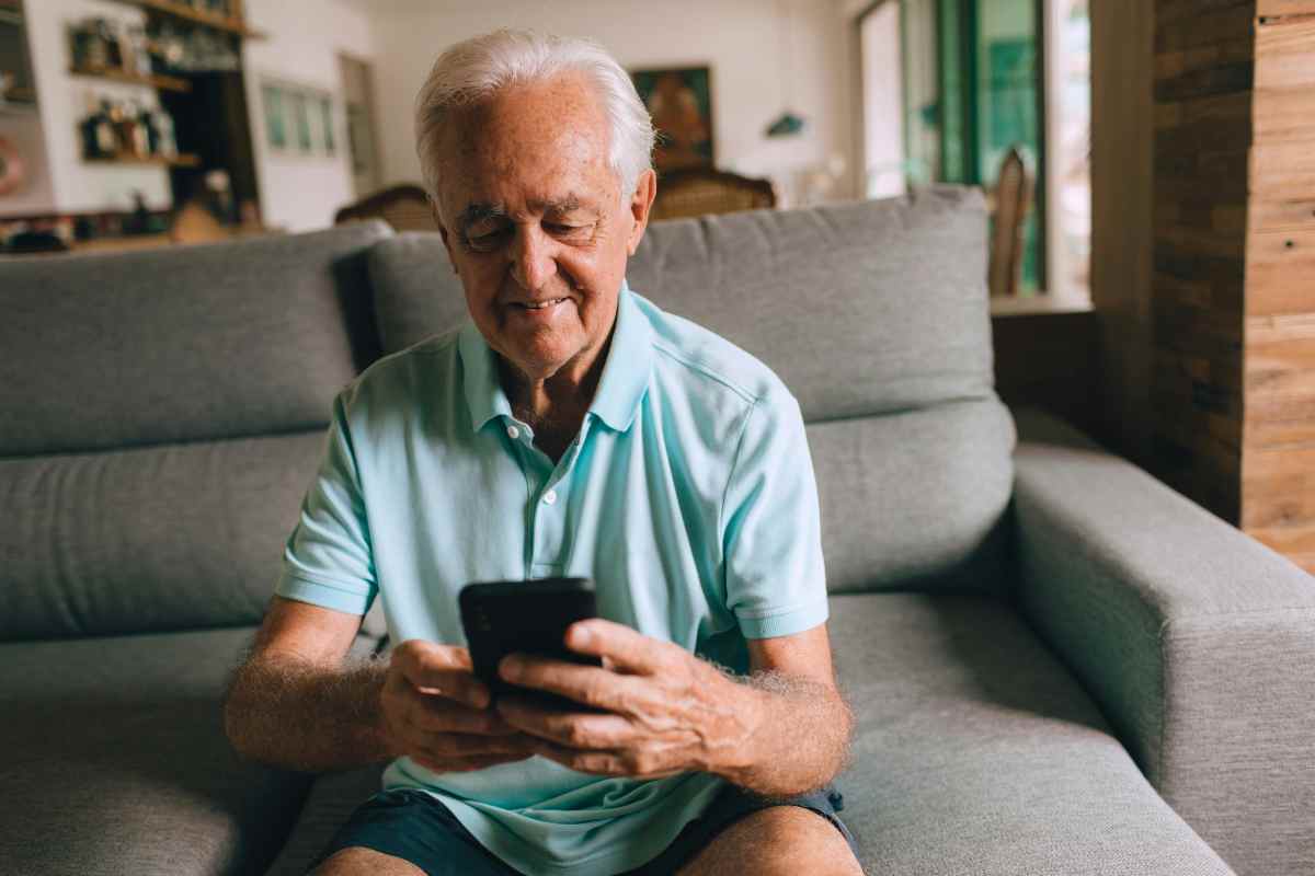 anziano che ha in mano uno smartphone