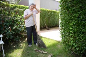 donna anziana pulisce il giardino
