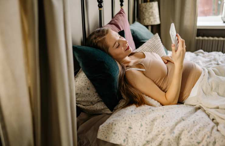 donna a letto con lo smartphone