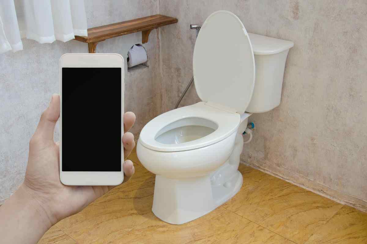 smartphone in mano in bagno